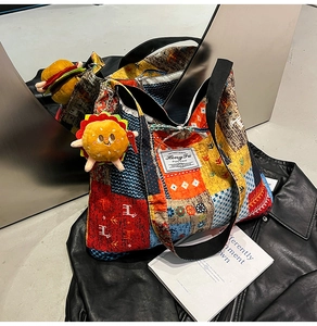 Detail of colorful patchwork canvas tote bag with graphic patterns and plush sun charm