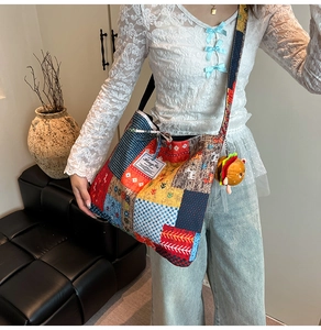 Close-up of canvas tote bag with colorful patchwork and a plush burger keychain charm