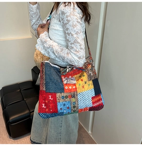 Detail view of colorful patchwork canvas tote bag with bohemian patterns and slim shoulder strap