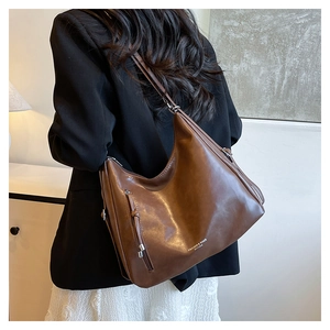 Model wearing a vintage brown matte leather tote bag with stylish zipper front pocket
