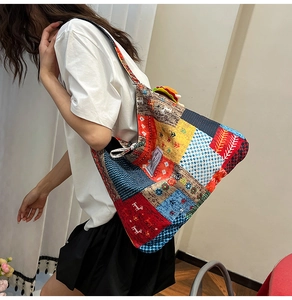 Side view of a large patchwork canvas tote bag featuring geometric and floral patterns