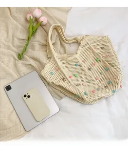 Detail of hand-woven tote bag with colorful beads next to a tablet and phone