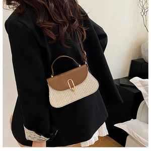 Détail du sac en paille tressée avec rabat en cuir brun et fermoir doré rotatif