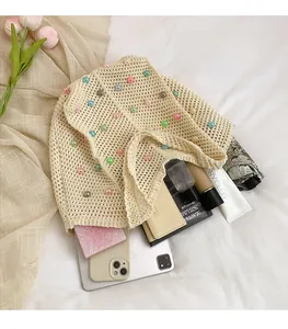 Macro view of cream crochet shoulder bag with colorful pearls and inner storage space