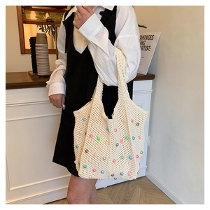 Detail of crochet knit shoulder bag with colorful beads and pearl accents for summer