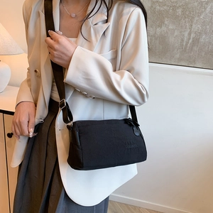 Minimalistische schwarze Nylon-Umhängetasche mit verstellbarem Riemen und Logo-Prägung