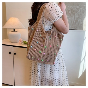 Detail of hand-woven crochet tote bag featuring multi-colored pearls for beach vacations