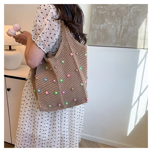 Detail of hand-woven shoulder bag featuring colorful pearl beads and cotton rope texture