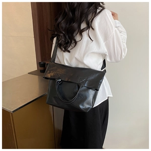 Vista detallada del bolso tote de cuero PU negro brillante con asas cilíndricas