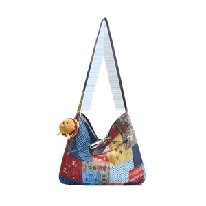 Ethnic patchwork canvas tote bag with colorful patterns and a small burger charm