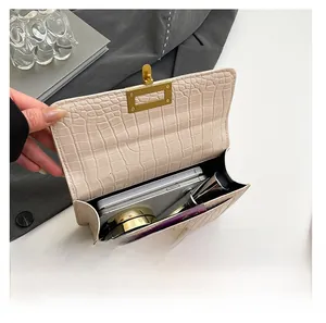 Vista interna del bolso bandolera beige con grabado de cocodrilo que muestra su capacidad