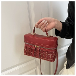 Detail of red tweed and faux leather patchwork mini bag with golden metal zipper