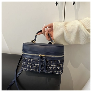 Navy blue box bag detail featuring gold-threaded tweed texture and metal zippers