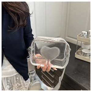 Dettaglio della borsa a tracolla trasparente in PVC con cuore argento e tracolla larga