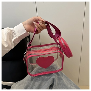 Dettaglio della borsa a tracolla in PVC rosa trasparente con patch cuore e borsellino