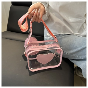 Dettaglio borsa a tracolla in PVC rosa trasparente con patch a cuore e borsellino