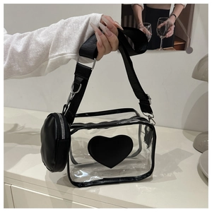 Dettaglio della borsa a tracolla trasparente con patch a cuore nero e mini borsa rotonda