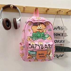 Roze Capybara cartoon rugzak met grote capaciteit hangend aan de muur met een koptelefoon
