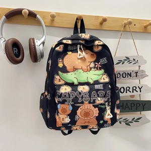 Detail van de zwarte rugzak met capybara-print hangend aan een houten wandhaak