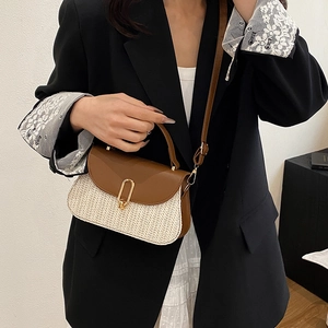 Sac bandoulière bicolore en cuir marron et paille tressée porté par un mannequin femme