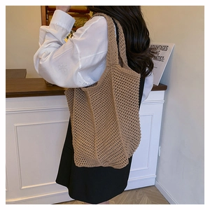 Detail of hand-woven hollow mesh tote bag in brown featuring artistic crochet texture