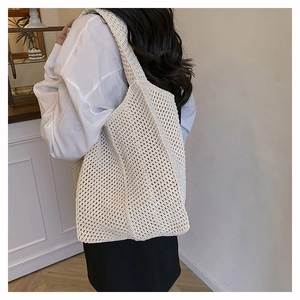 Beige hollow crochet woven tote bag shown on model with bohemian mesh knit texture