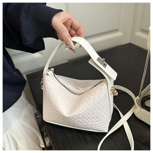 Vue détaillée d'un sac Boston tressé blanc montrant la texture, l'anse et la bandoulière