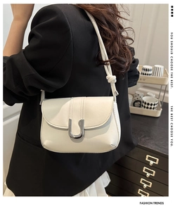 Detail of white PU leather shoulder bag featuring silver U-shaped buckle and knotted strap