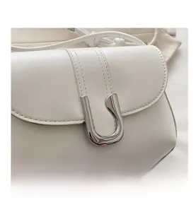 Detailed close-up of white leather texture and elegant silver U-shaped metal buckle