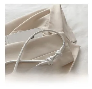 Detail of minimalist cream leather strap with silver metal tips and knot design