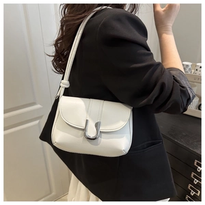 Close-up of white leather underarm bag with silver U-shaped buckle and knot detail