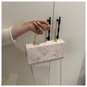 Detail of lace handbag with 3D butterfly embroidery and gold metal ring handle
