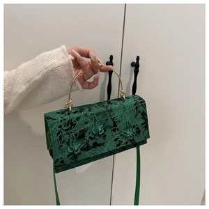 Close-up of green vintage lace handbag with 3D butterfly embroidery and gold handle