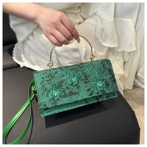 Macro shot of green lace handbag featuring detailed 3D butterfly embroidery and gold handle