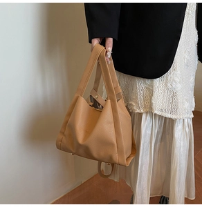 Light camel pebbled leather bucket bag with top handles and adjustable shoulder strap