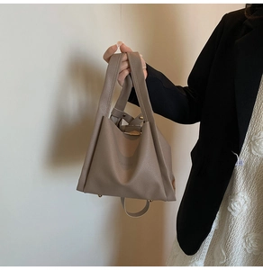 Close-up of lychee grain PU leather bucket bag with metal protective feet on base