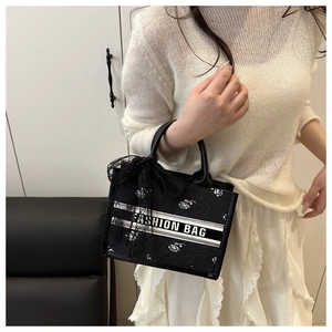 Detail of floral embroidery and lace bow on a black tote bag with Fashion Bag text