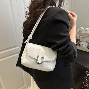 Minimalist white leather shoulder bag with silver U-shaped clasp and knotted strap detail