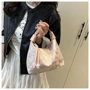Detalle del bolso de encaje rosa con aplicaciones florales 3D y borlas de cuentas