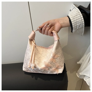 Detalle del bolso hobo de encaje rosa con lazos de malla 3D y detalles del asa