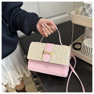 Dettaglio della borsa a tracolla in pelle rosa e paglia con fibbia dorata a forma di H