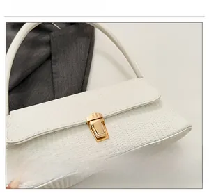 Close-up of white woven texture handbag featuring a premium gold metallic clasp closure