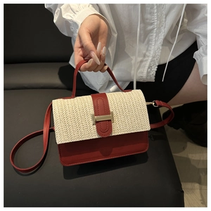 Dettaglio della trama in pelle rossa e paglia di una borsa a tracolla alla moda