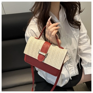 Dettaglio della patta in paglia intrecciata e pannello in pelle rosso scuro sulla borsa