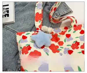 Floral canvas tote bag details showing a blue star plush charm and purple flower print