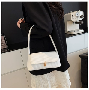 Detail of white woven texture shoulder bag with gold square buckle on casual outfit