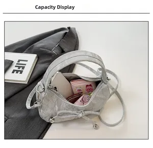 Capacité intérieure d'un sac à main plissé gris clair avec rangement pour téléphone