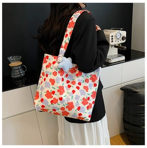 Floral canvas tote bag with rose print and a blue star plush charm on shoulder