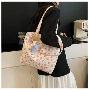 Close-up of floral canvas tote bag with pink rose prints and a star plush charm