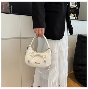 Détail du sac hobo en cuir blanc crème avec nœud élégant et logo en métal argenté